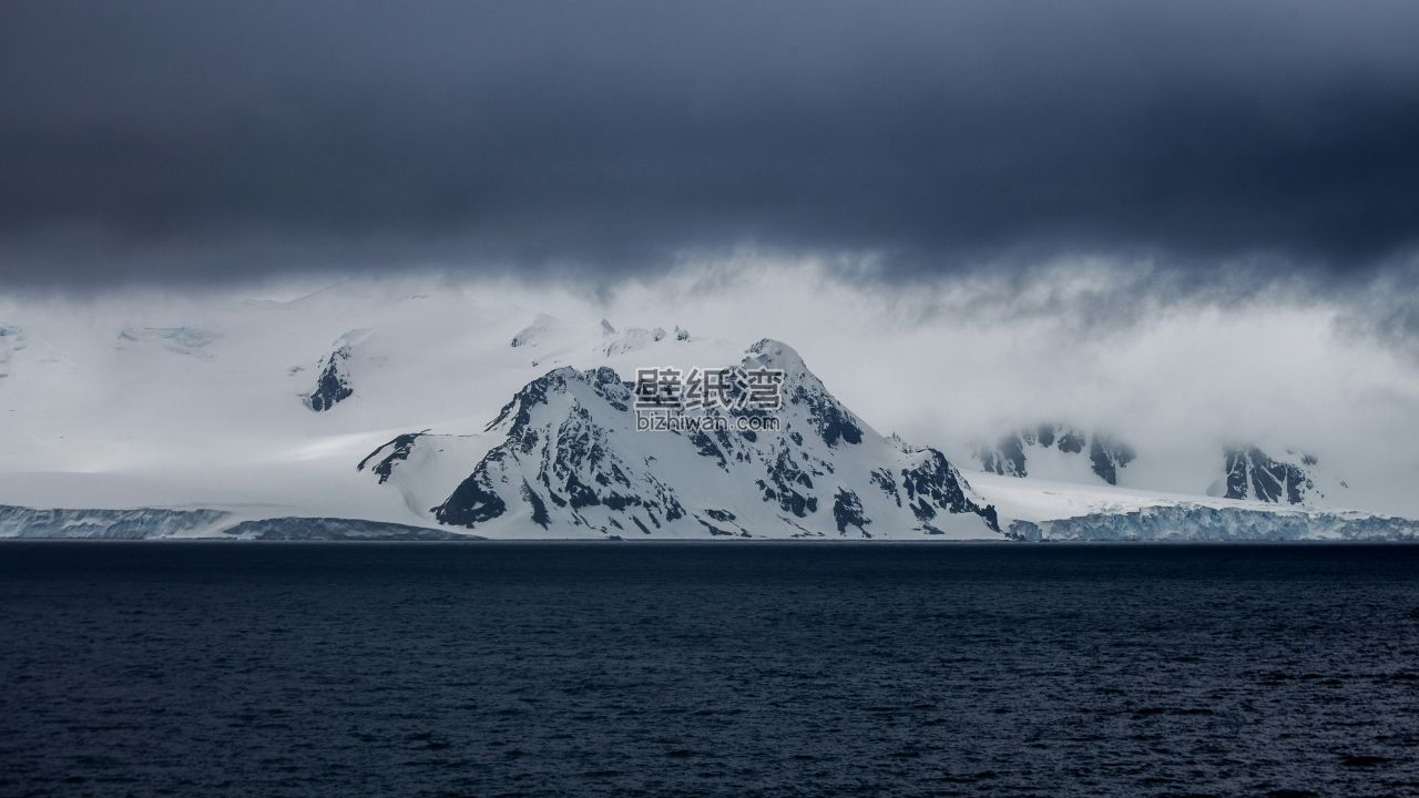 深蓝色的天空下，雪山与海洋电脑壁纸图片