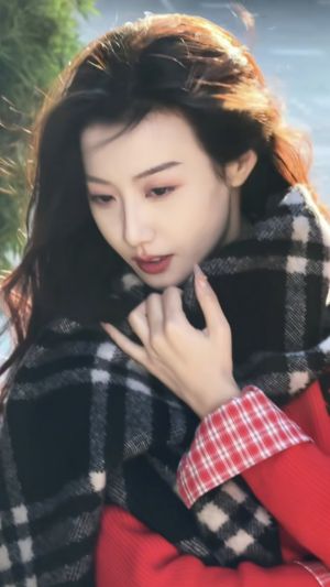 围着黑白格子围巾，穿着红色衣服，手托下巴的美女手机壁纸图片