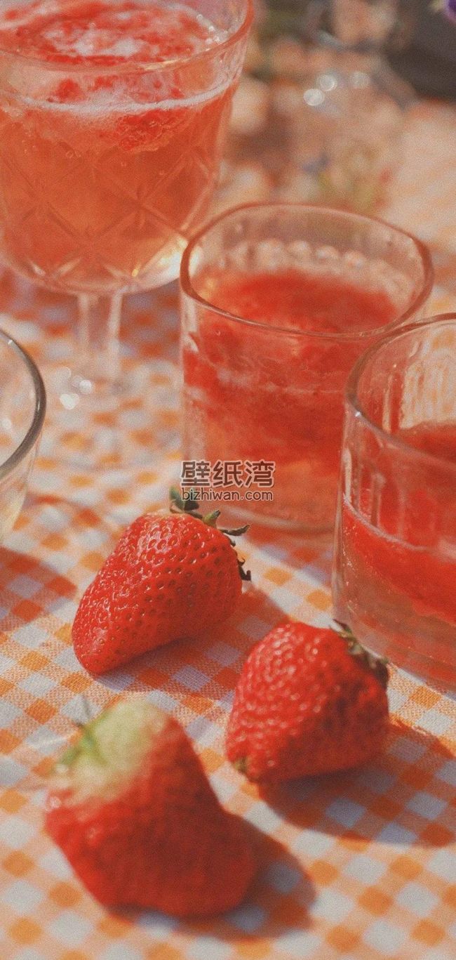 草莓汁与新鲜草莓摆放在格子桌布上