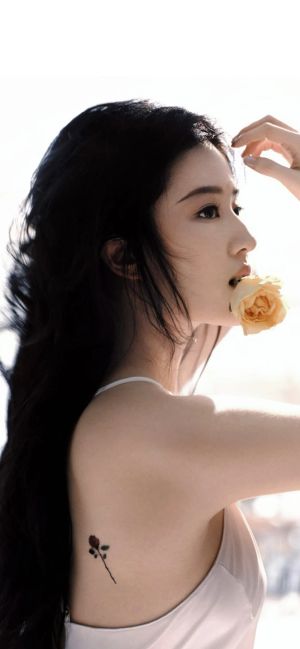 刘亦菲侧脸手持黄色花朵，肩上有小花纹身，刘亦菲锁屏手机壁纸