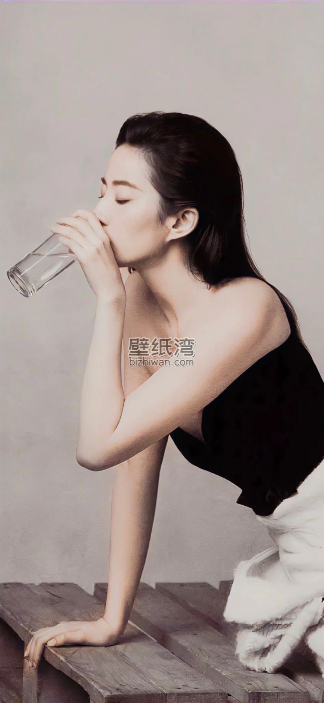 刘亦菲穿着黑色上衣坐在木凳上喝水
