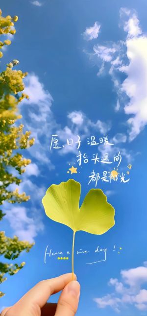 蓝天白云下，手握银杏叶，背景有绿色植物和温暖的文字祝福