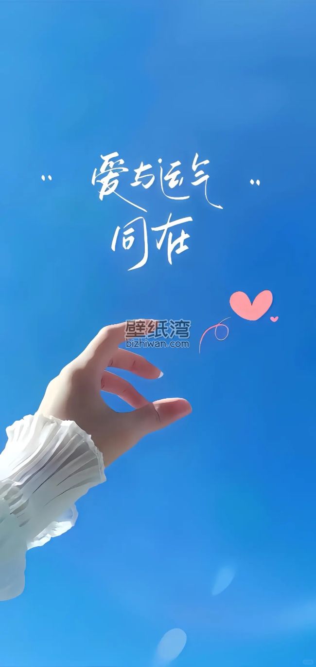 蓝天下，一只手伸向带有文字“爱与运气同在”的粉色心形图案，手机壁纸图片