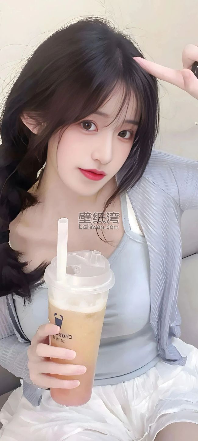 年轻美女手持奶茶，穿着休闲服装，背景为室内环境