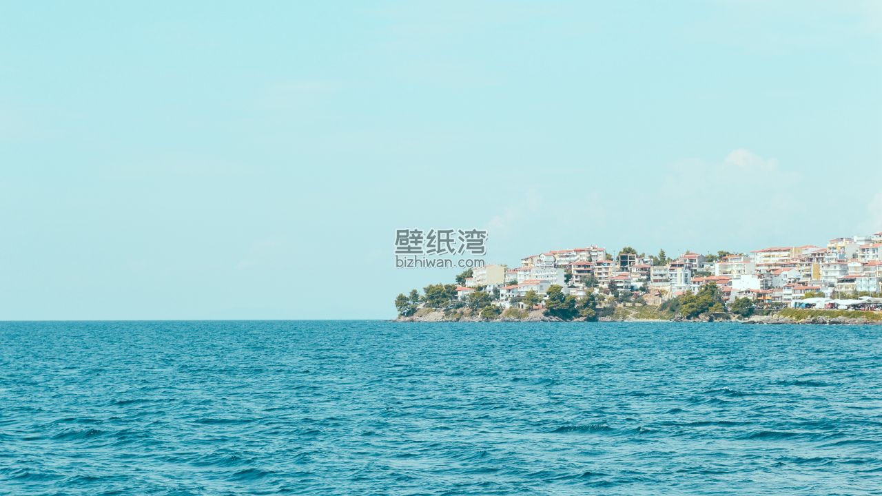 海边小镇的风景，远处可见一排建筑物和绿色植被，4K电脑壁纸下载