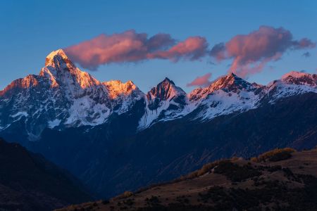 雪山在夕阳下被染成粉红色，云彩映衬出壮丽的景色 4K壁纸下载