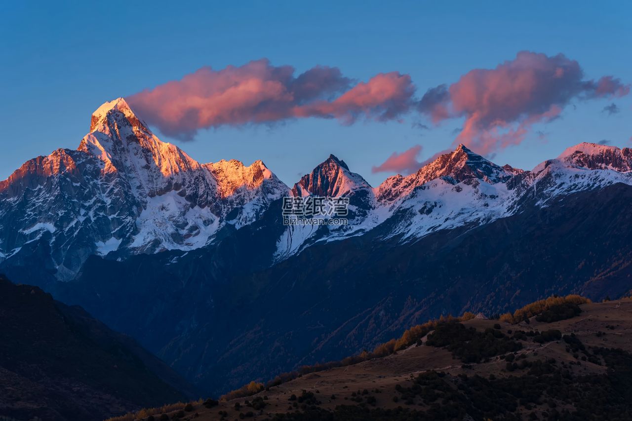 雪山在夕阳下被染成粉红色，云彩映衬出壮丽的景色 4K壁纸下载