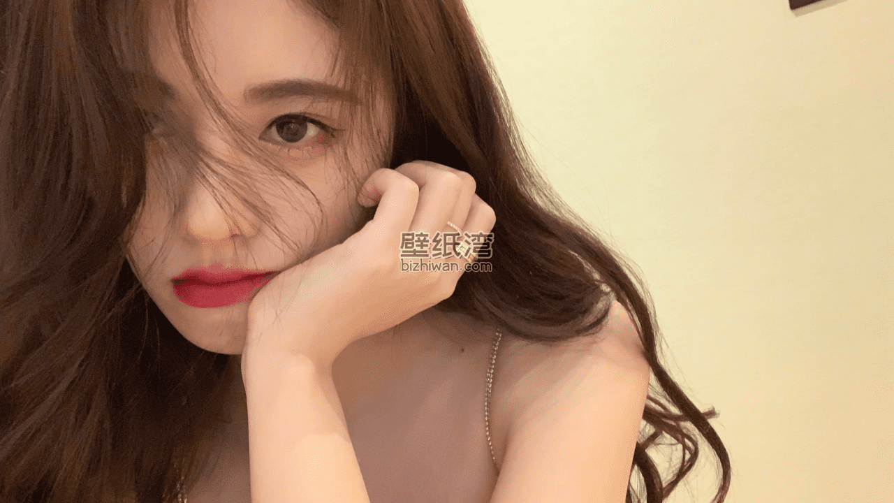 长发美女侧脸特写，手托脸，浅色墙面背景壁纸图片