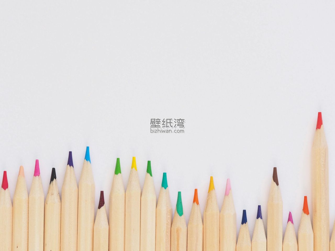 一排彩色铅笔整齐排列在白色背景上