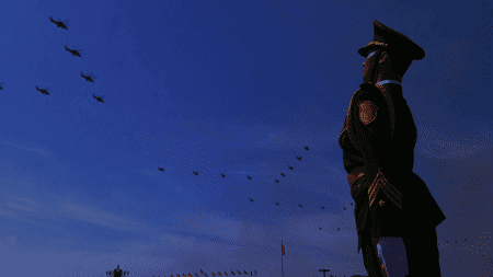 阅兵现场身穿军装的士兵在广场上敬礼，蓝天和飞行编队