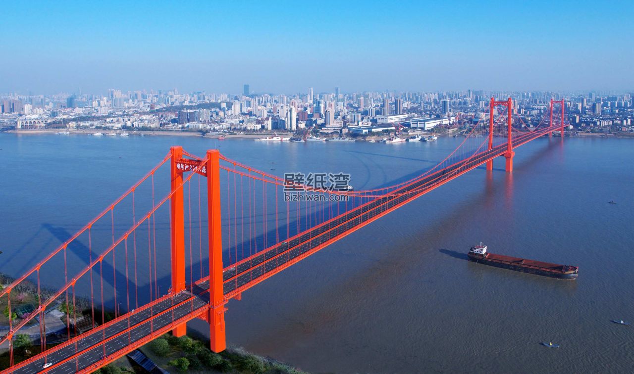 武汉长江大桥全景，红色桥梁横跨江面，城市天际线清晰可见